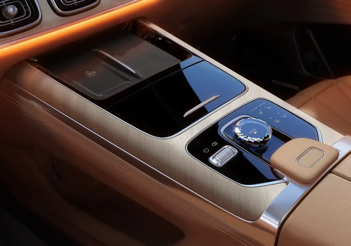 Close-up of the Jaecoo J8 center console with rotary controls, wireless charging pad, and premium trim.