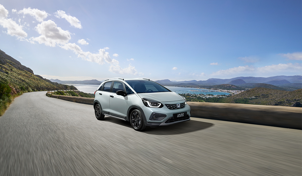 All-new Honda Jazz for 2023 in Urban Grey on hilly coastal road.