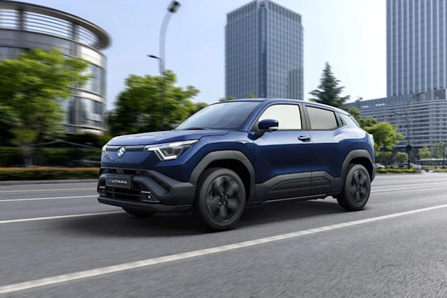 blue Suzuki e Vitara driving in the city