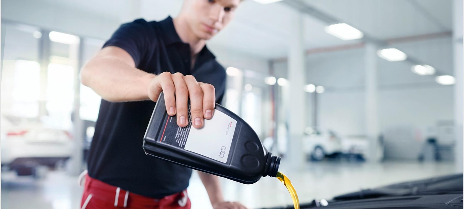 Mechanic Pouring Oil into vehicle