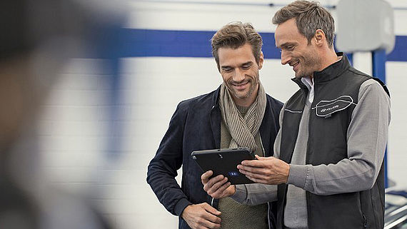 Mechanic showing a customer some information