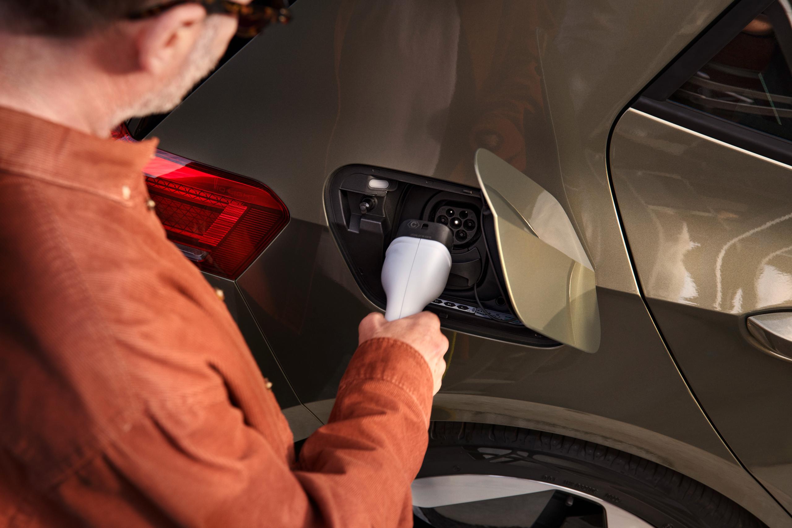 Person Putting Volkswagen Electric Car On Charge