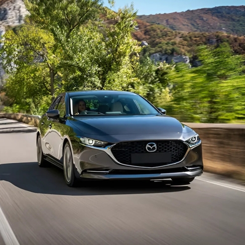 Mazda3 Saloon driving in an outdoor setting