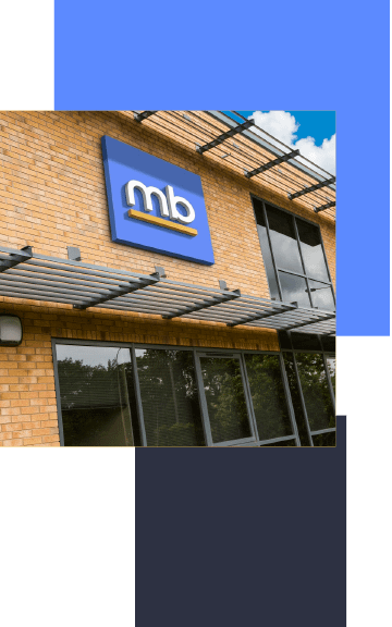 Exterior view of MD Advertising building featuring brick facade, large glass windows and prominent MB branded signage mounted on the frontage