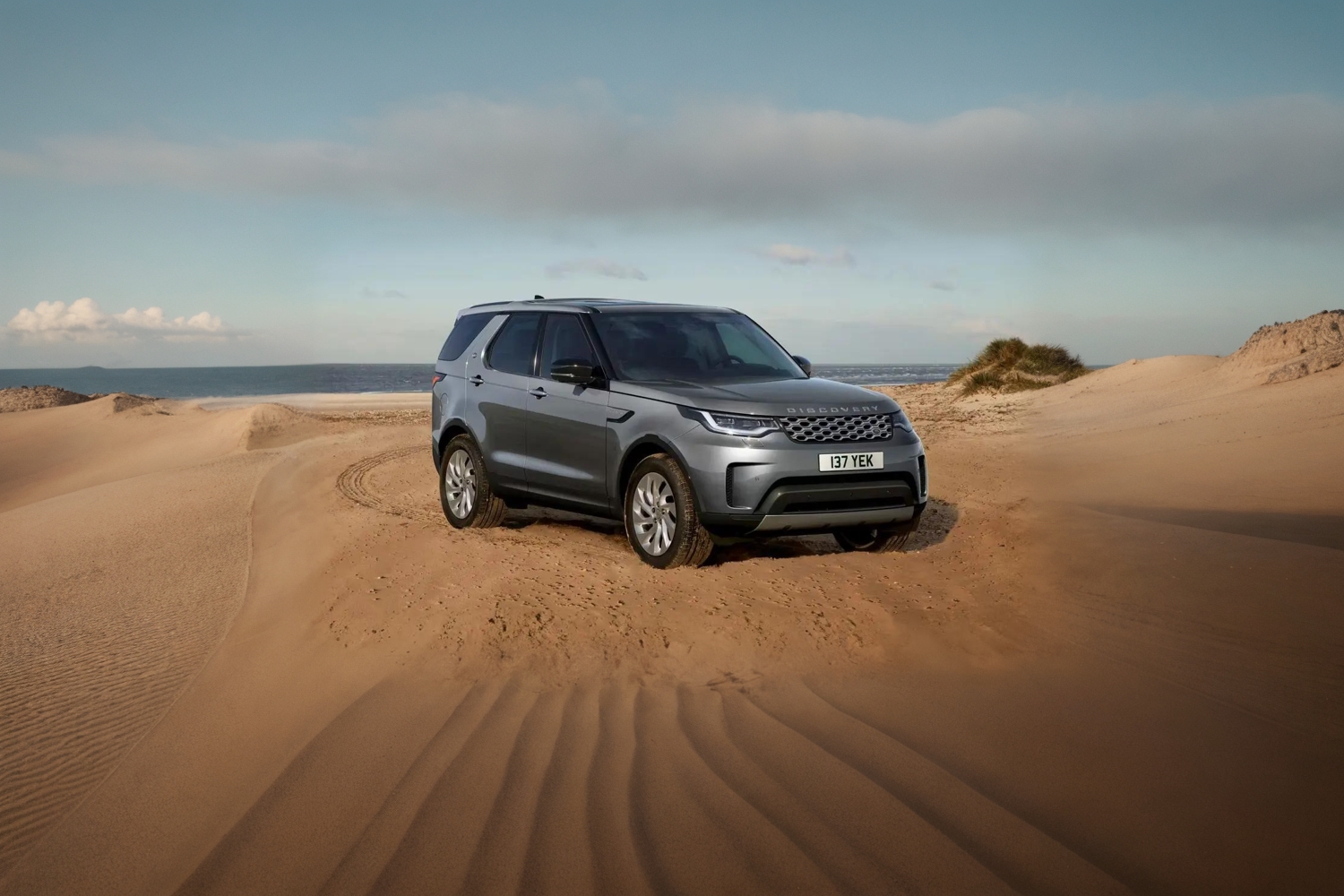 Grey Discovery Commercial Parked In Sand