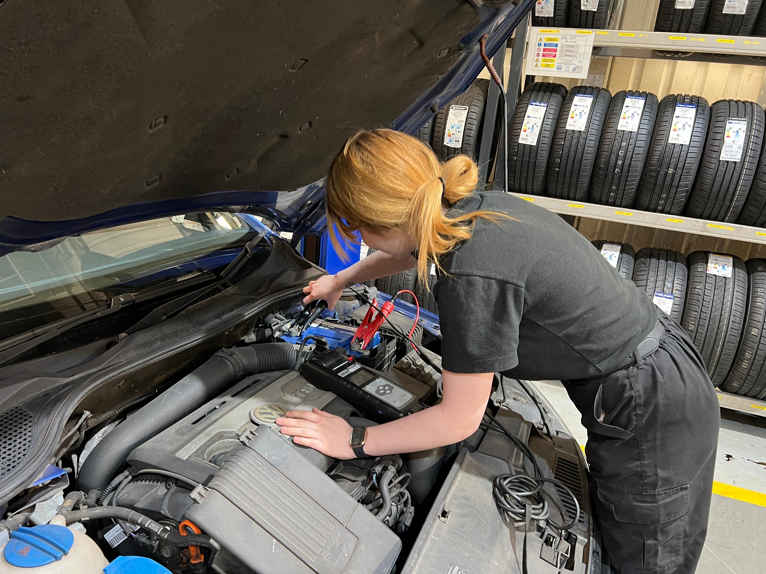 Female mechanic fixing a car engine