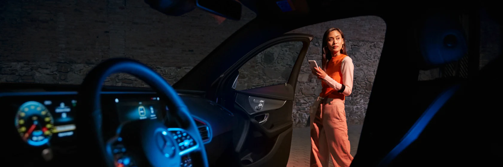 Woman standing outside Mercedes on phone