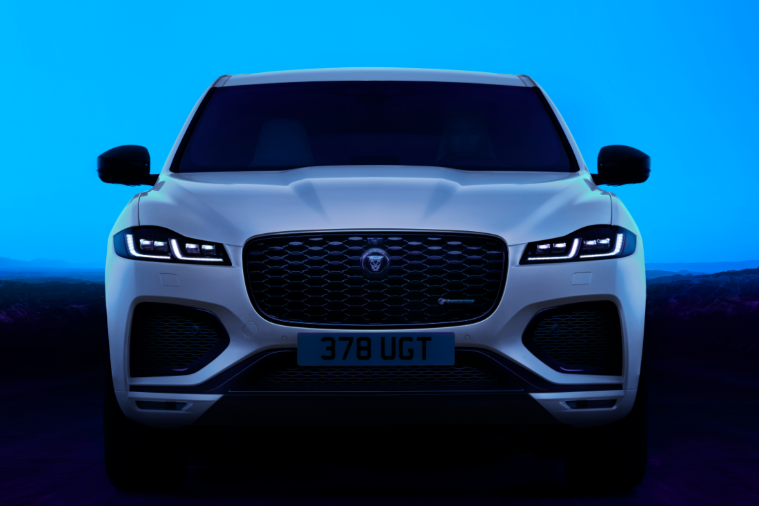 Front view of Jaguar F-PACE with LED headlights illuminated.