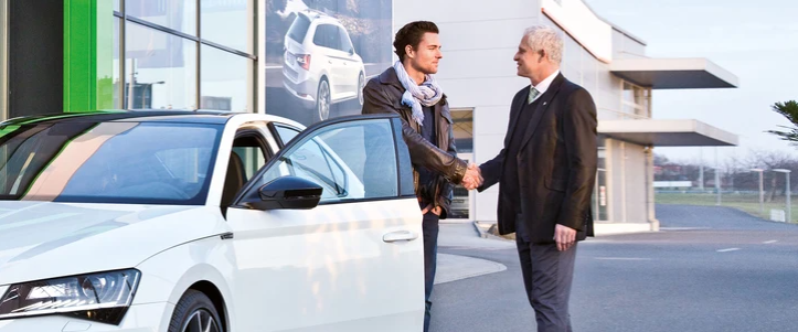 Two People Shaking hands next to SKODA