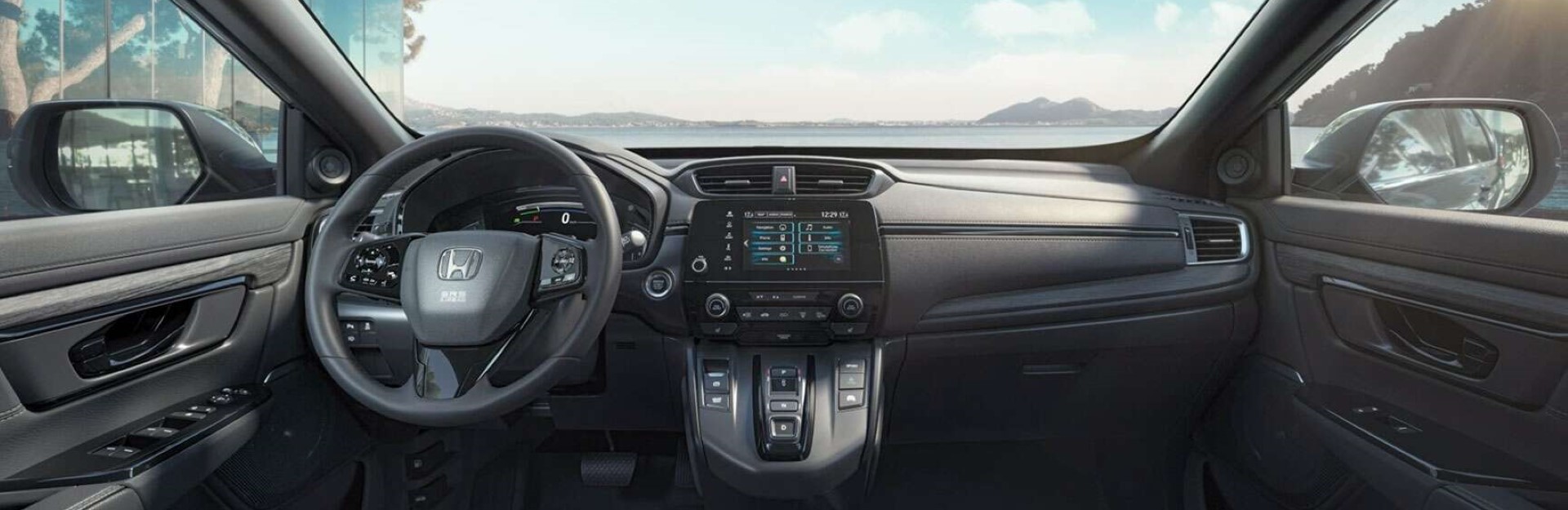 Drivers view of a new honda car looking onto a lake.