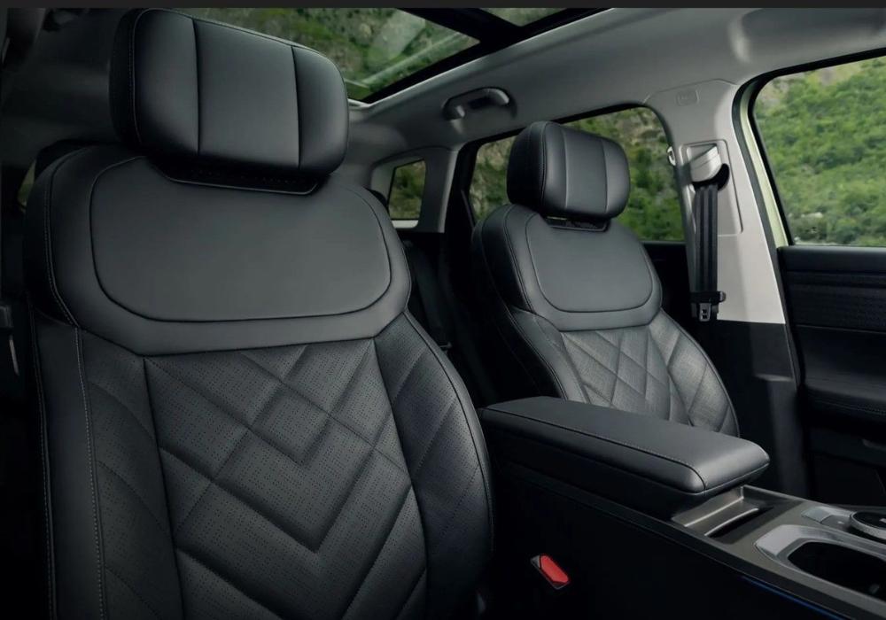 Close-up of the Jaecoo 7 front seats featuring black leather upholstery with patterned stitching and a panoramic roof above.