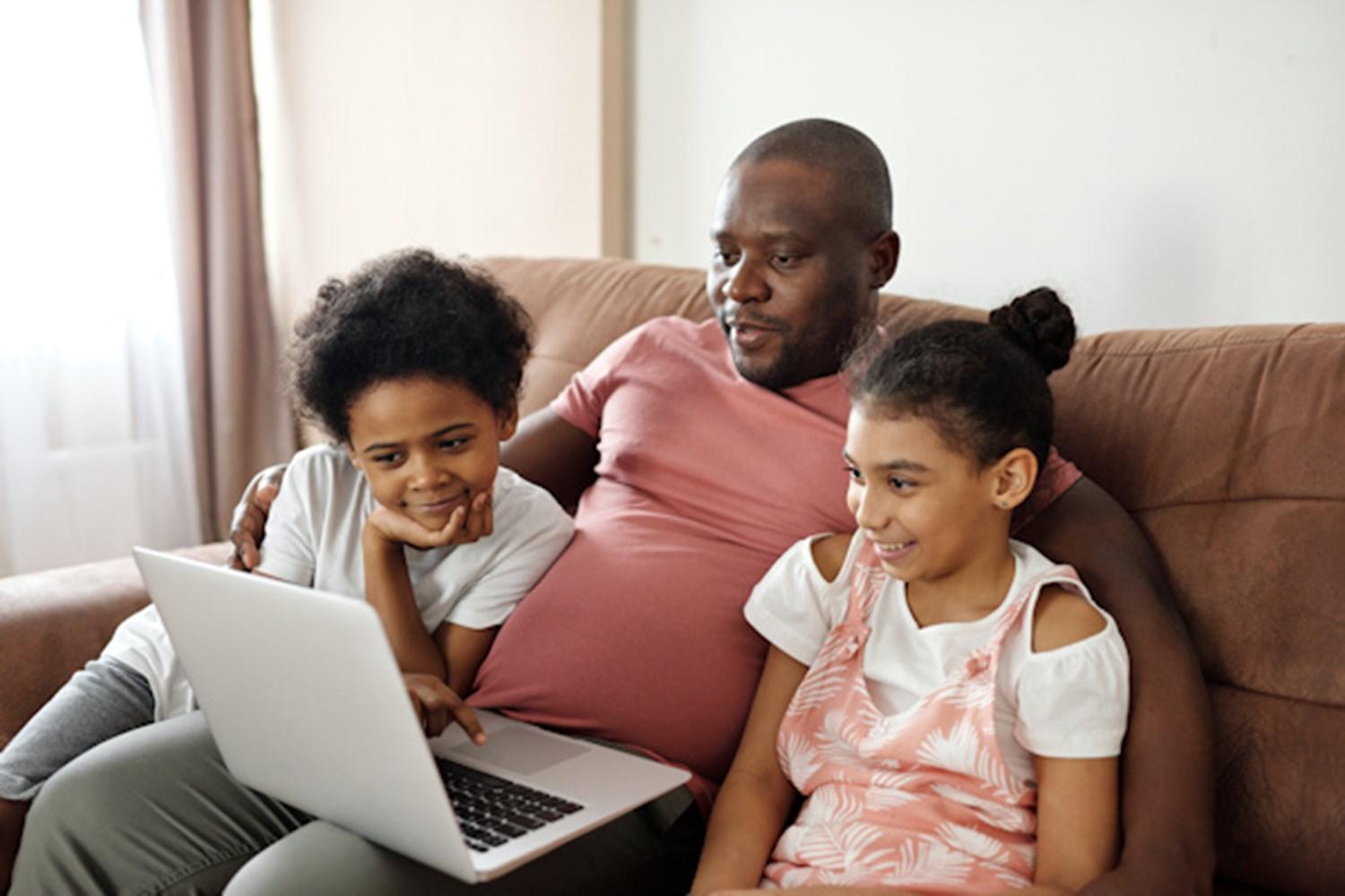 Parent with children looking at laptop