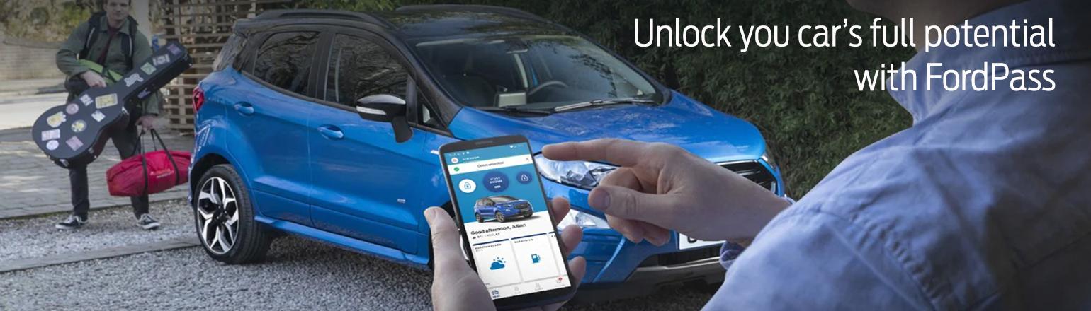 Smartphone displaying the FordPass app with a Ford EcoSport in the background.