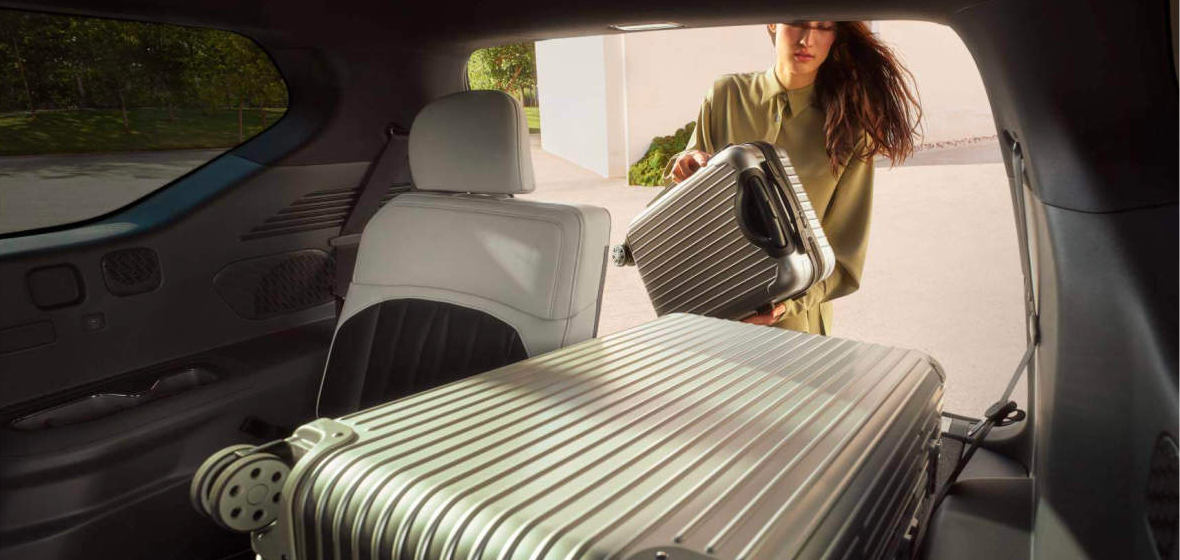 Woman packing suitcases into a Kia EV9