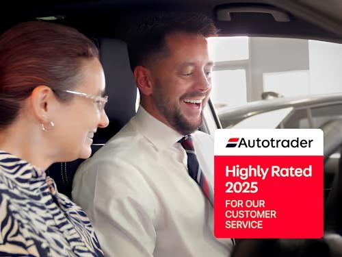 Sales advisor guiding a customer through vehicle features in the showroom.