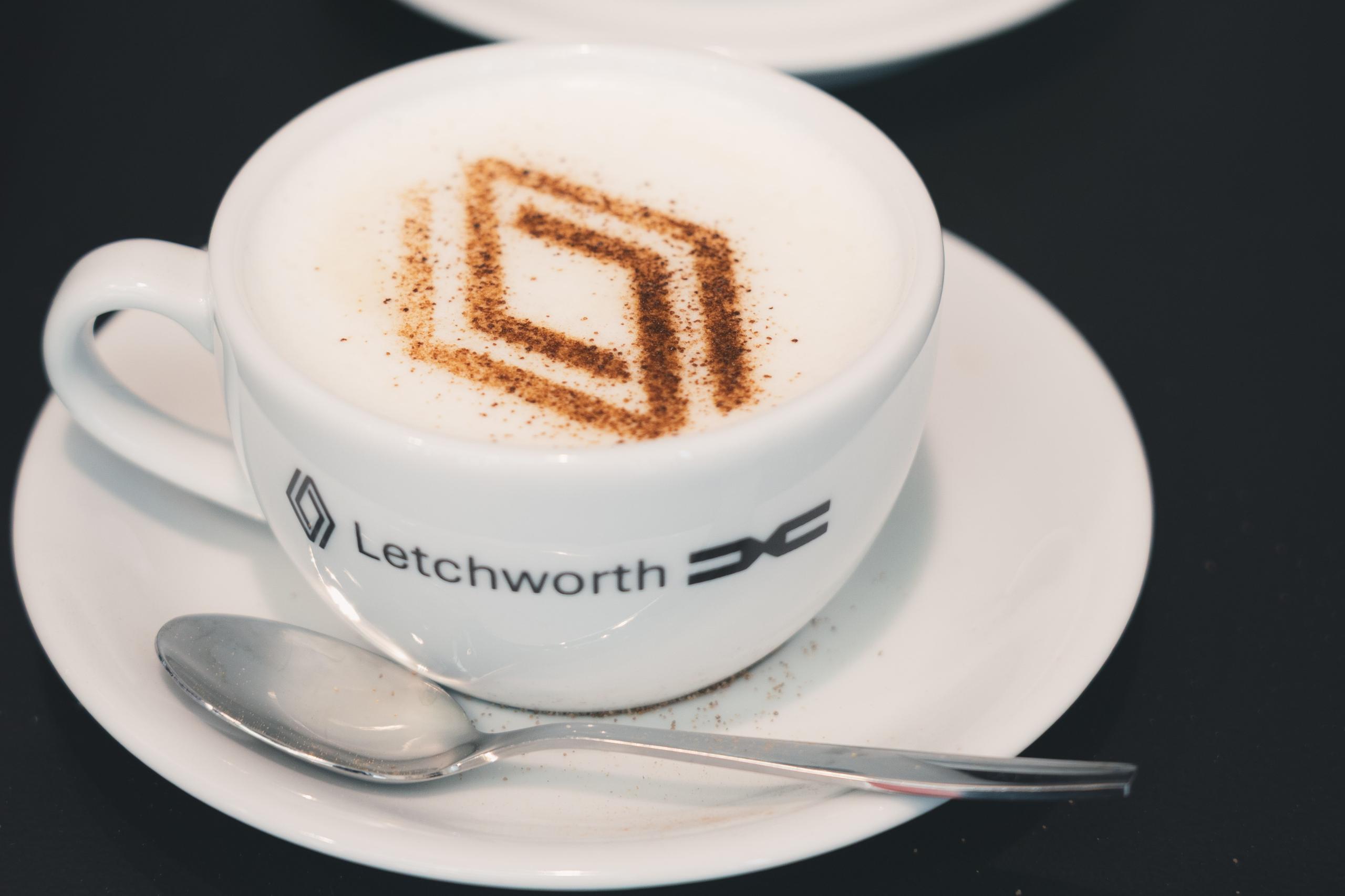 Cup of coffee with chocolate on top in the shape of the Renault Logo